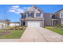 Charming two-story home with stone accents, well-maintained lawn, and a two-car garage at 356 Runner Stone Ln, Fort Mill, SC 29715
