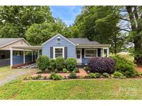Charming blue home with lush landscaping and a well-manicured front yard with black shutters at 430 Sells Rd, Salisbury, NC 28144