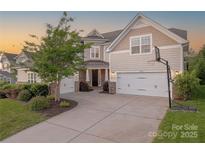 Charming two-story home with a manicured lawn, three-car garage, and a basketball hoop on the side at 5128 Oakhaven Ln, Fort Mill, SC 29708