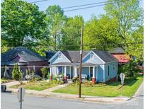 Charming blue home with inviting front porch and well-maintained lawn and shrubs at 600 E 35Th St, Charlotte, NC 28205