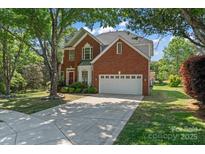 Charming brick home with a well-manicured lawn and a large shade tree in a desirable neighborhood at 8211 Abbottsgate Ln, Charlotte, NC 28269