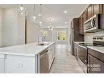 Bright kitchen features stainless appliances, a stylish island with a sink, and modern pendant lighting at 842 Van Every St, Charlotte, NC 28205