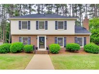 Charming two-story brick home with manicured landscaping, black shutters, and inviting entryway at 8525 Castlekeep Rd # 26, Charlotte, NC 28226