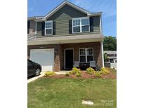 Charming two-story townhome features a well-manicured lawn and covered front porch with seating at 9340 Grand Valley Dr, Charlotte, NC 28213
