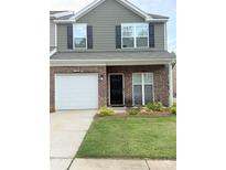 Charming two-story home featuring a brick facade, attached garage, and well-maintained lawn at 9340 Grand Valley Dr, Charlotte, NC 28213
