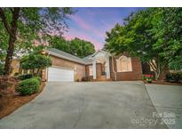 Charming single-story brick home featuring an attached garage, columned entrance, and well-manicured landscaping at 1245 Bellemeade Ln, Charlotte, NC 28270