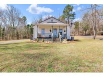 Charming cottage-style home featuring a cozy front porch and a well-maintained lawn at 1339 Hill St, Albemarle, NC 28001