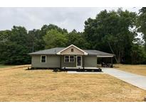 Charming single-story home with olive green siding, covered carport, and newly seeded front yard at 1428 E Main St, Cherryville, NC 28021