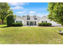 Charming white home with dormers, a covered porch, and a lush green lawn at 1728 Privette Rd, Matthews, NC 28105