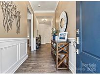 Inviting entryway features wood-look flooring, stylish decor, and a convenient display table at 213 Warbler Dr, Wesley Chapel, NC 28110