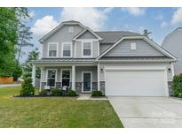 Charming two-story home featuring stone accents, a two-car garage, and a well-manicured lawn at 3205 Berry Creek Rd, Charlotte, NC 28214