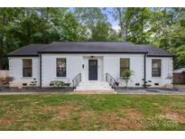 Charming single-story home featuring a painted brick facade, dark trim, and well-maintained landscaping at 3538 Denson Pl, Charlotte, NC 28215