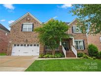 Beautiful brick home featuring a two-car garage, manicured lawn, and traditional architectural details at 422 Deer Brush Ln, Waxhaw, NC 28173