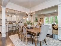 Elegant dining room featuring a wooden table, chandelier, and seamless flow to the kitchen and living room at 5130 Mount Clare Ln, Charlotte, NC 28210