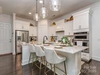 Bright kitchen features a marble island with seating, modern appliances, and decorative pendant lighting at 5130 Mount Clare Ln, Charlotte, NC 28210