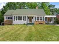 Charming home with a well-manicured lawn, green shutters, and stone accents at 514 W Sumter St, Shelby, NC 28150