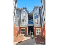 Charming two-story condo with brick accents and a blue-painted walkway against a clear sky at 529 N Graham St # 3F, Charlotte, NC 28202