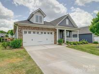 Charming home featuring a stone facade, gray siding, manicured lawn, and a convenient two-car garage at 6266 Swanport Rd, Lancaster, SC 29720