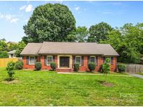 Charming single-story brick home with well-manicured lawn, trimmed shrubs and double front doors at 6301 Cherrycrest Ln, Charlotte, NC 28217