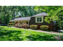 Charming home featuring mature landscaping, brick accents, and a welcoming facade with a cozy front porch at 701 5Th Ne Ave, Conover, NC 28613