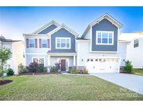 Charming two-story home featuring a manicured lawn, two car garage and tasteful landscaping at 9586 Kartey Nw Ave, Concord, NC 28027