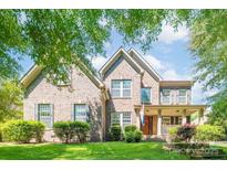 Charming two-story brick home with well-maintained landscaping and inviting front porch at 11224 Warfield Ave, Huntersville, NC 28078