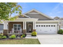 Charming single-Gathering home featuring a well-manicured lawn and stone accents on the front exterior at 1221 Brookcrest Ln, Fort Mill, SC 29708