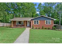 Charming brick home featuring a walkway leading to the front door and a well-manicured lawn at 2113 Woodlawn St, Kannapolis, NC 28083