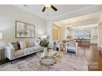 Bright, open living room with modern furnishings and decor flowing into the dining area and kitchen at 258 Iverson Way, Charlotte, NC 28203