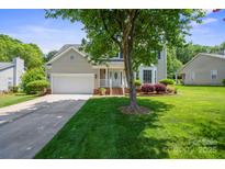 Charming home with a well-manicured front yard, mature tree, and attached two car garage at 374 Queens Sw Dr, Concord, NC 28025