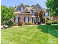 Charming two-story brick home with a well-manicured lawn and lush landscaping at 5321 Kathryn Blair Ln, Charlotte, NC 28226