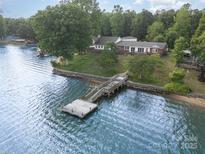 Picturesque waterfront home featuring a private dock and serene lake views surrounded by lush greenery at 565 Shore Acres Rd, Salisbury, NC 28146