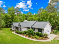 Charming single-story home with a well-manicured lawn, mature trees and a lovely landscaped front yard at 5903 Wm Griffin Rd, Monroe, NC 28112