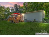 Charming home featuring a lovely wooden deck perfect for outdoor relaxation and entertaining under bright red umbrellas at 743 Dream Ln, Salisbury, NC 28146