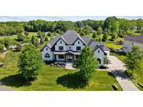 Stunning aerial view of a modern, white-painted brick home with manicured lawn and mature trees at 1005 Grand Oak Dr, Waxhaw, NC 28173