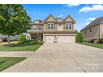 Charming two-story home with a well-manicured lawn and a two-car garage at 1011 Potomac Rd, Indian Trail, NC 28079