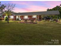 Charming brick home features a covered carport and a lush, expansive front lawn at 1160 Redmon Rd, Cleveland, NC 27013