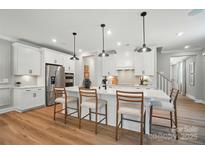 Bright kitchen features a center island with bar stool seating, stainless appliances, and white cabinetry at 12036 Lavinia Ln, Charlotte, NC 28277
