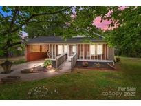 Charming brick home featuring a covered front porch, landscaped yard and walkway leading to the entrance at 1233 E Cannon Ave, Albemarle, NC 28001