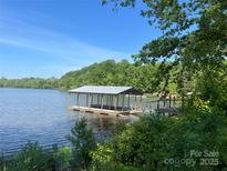 Picturesque waterfront property featuring a private covered dock for boating and enjoying serene lake views at 124 Clipper Ln, Mooresville, NC 28117