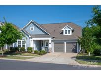Charming home with a blue exterior, a two-car garage, a covered porch, and well-maintained landscaping at 1260 Thomas Knapp Pkwy, Fort Mill, SC 29715