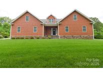 Charming home featuring a well-manicured lawn, shingle siding and stone foundation at 15027 Beatties Ford Rd, Huntersville, NC 28078
