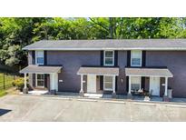 Brick two-story townhome with covered porch, black shutters, and ample parking at 1512 Seigle Ave # 2, Charlotte, NC 28205