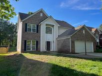 Charming two-story home with brick and vinyl siding, an attached two car garage, and a well-manicured lawn at 16017 Woodcote Dr, Huntersville, NC 28078