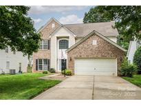 Charming two-story brick home featuring an attached two-car garage and well-maintained landscaping at 16017 Woodcote Dr, Huntersville, NC 28078