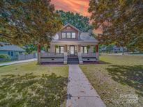 Charming two-story home features a welcoming front porch and meticulously landscaped front yard at 232 W Wilson Ave, Mooresville, NC 28115
