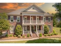 Stunning brick home with a double porch, columns, and beautifully landscaped front yard at 4117 Wallbrook Dr, Matthews, NC 28105
