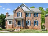 Beautiful brick two-story home with blue shutters and well-manicured front lawn in a sought-after neighborhood at 4161 Deerfield Dr, Concord, NC 28027