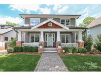 Charming two-story home with a welcoming front porch, lush lawn and beautiful landscaping at 421 Mcdonald Ave, Charlotte, NC 28203