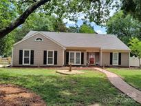 Charming single-story home with a well-manicured lawn, brick walkway, and neutral siding at 5601 Carmel Station Ave, Charlotte, NC 28226